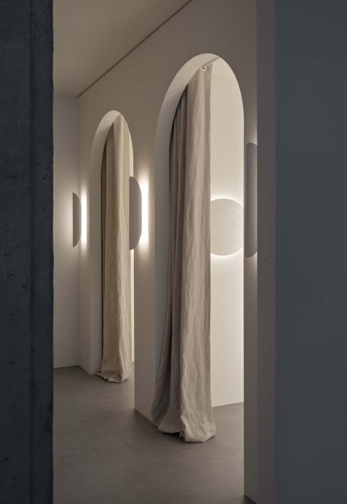 Helle Bögen mit Vorhängen und indirektem Licht im modernen Wellbeing Studio.