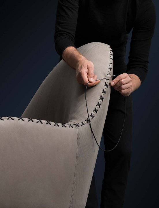Person näht Sessel von Hand zu