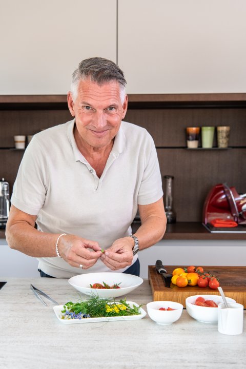 Sternekoch Heiko Nieder bereitet in seiner Küche einen Salat zu